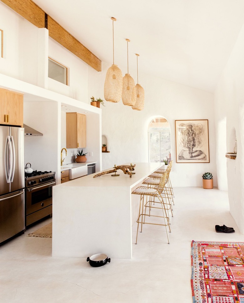 Desert kitchen with woven pendant lights and white kitchen island