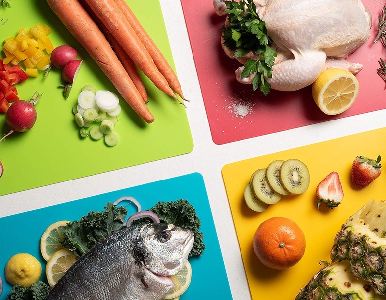 four different colored cutting boards with different foods