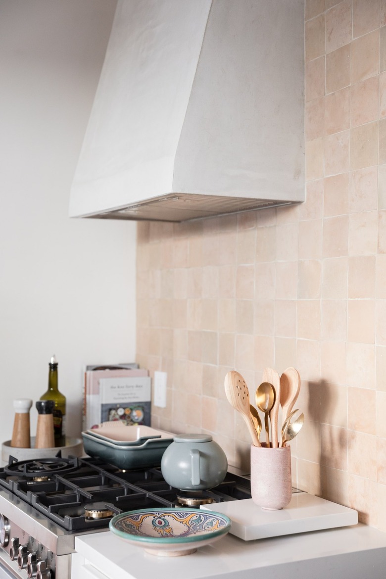 kitchen oven and hood with blush backsplash