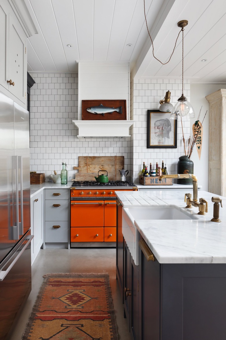 white midcentury modern kitchen backsplash idea with tile backsplash and orange oven
