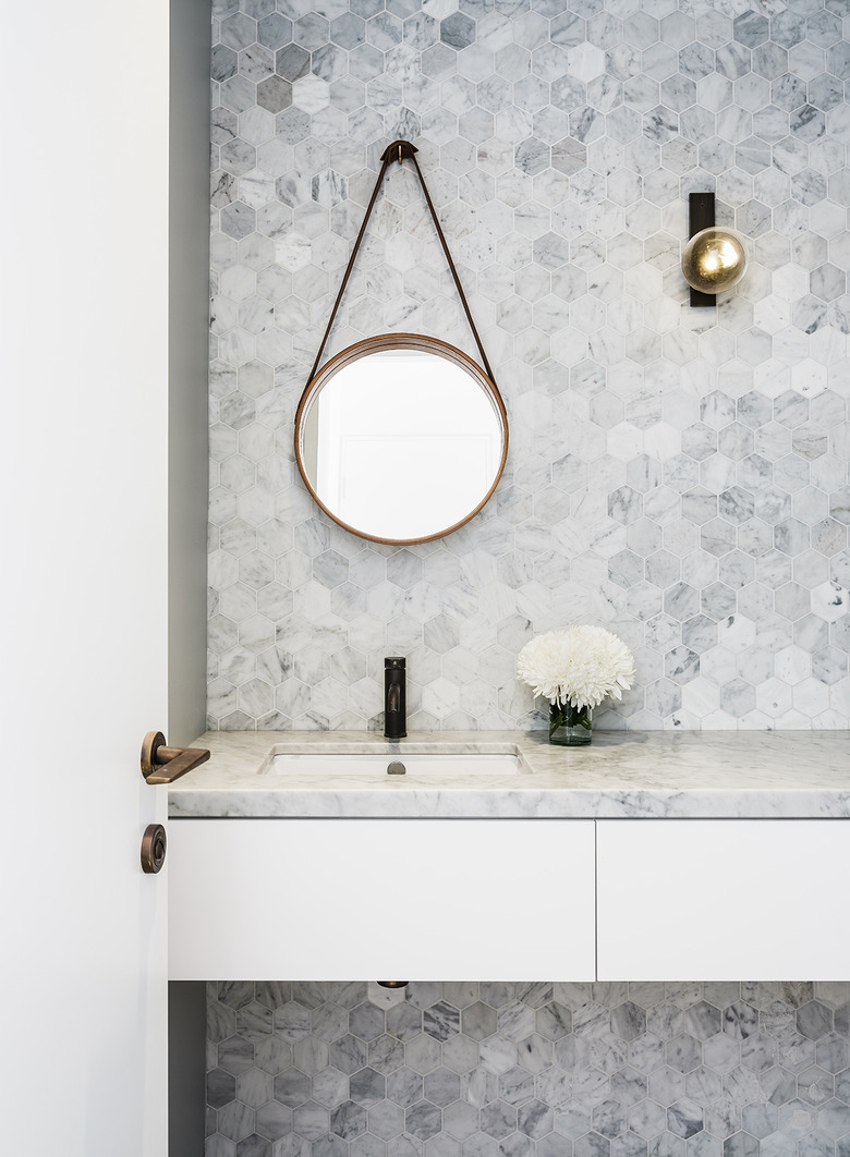 wall sconce bathroom light fixture with hexagonal wall tile and marble countertop