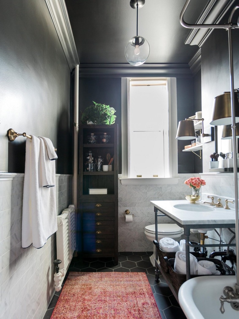 Black and white bathroom with black painted walls and black hex tile