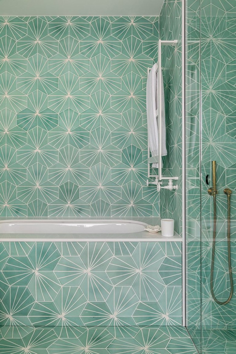 Hollywood regency bathroom with floor-to-ceiling blue green sunburst tile.