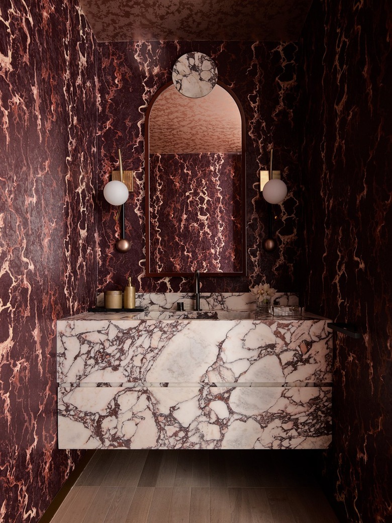 Modern Hollywood regency powder bathroom in burgundy and white with marble slab vanity