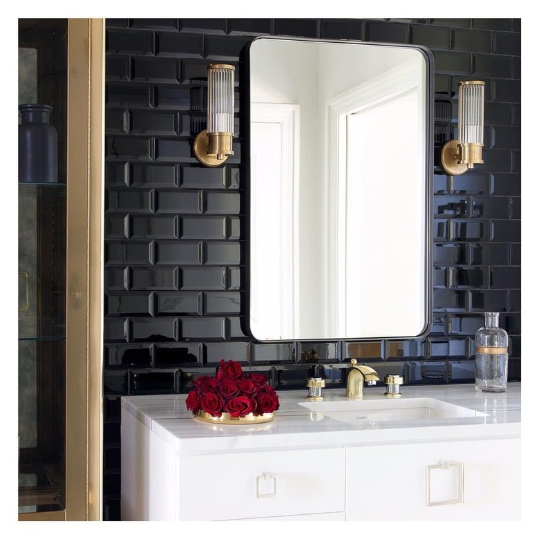 Modern Hollywood Regency bathroom with black tile wall