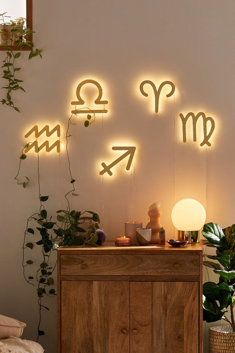 Zodiac sign LED lights on wall with wood cabinet below