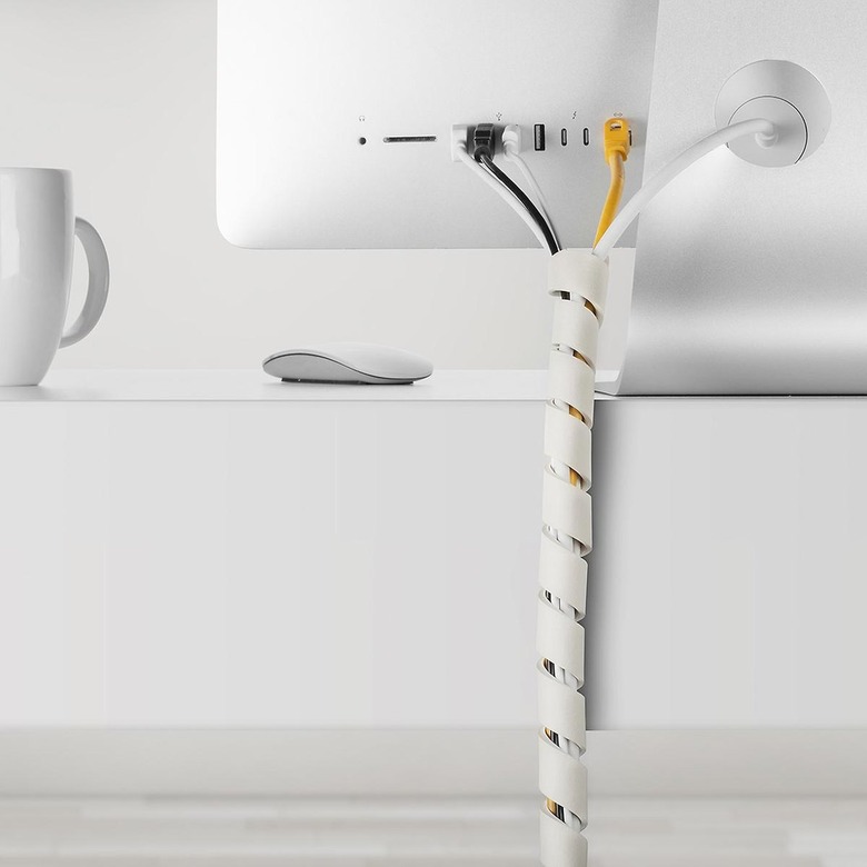 white cable Slinky behind desk containing several cords