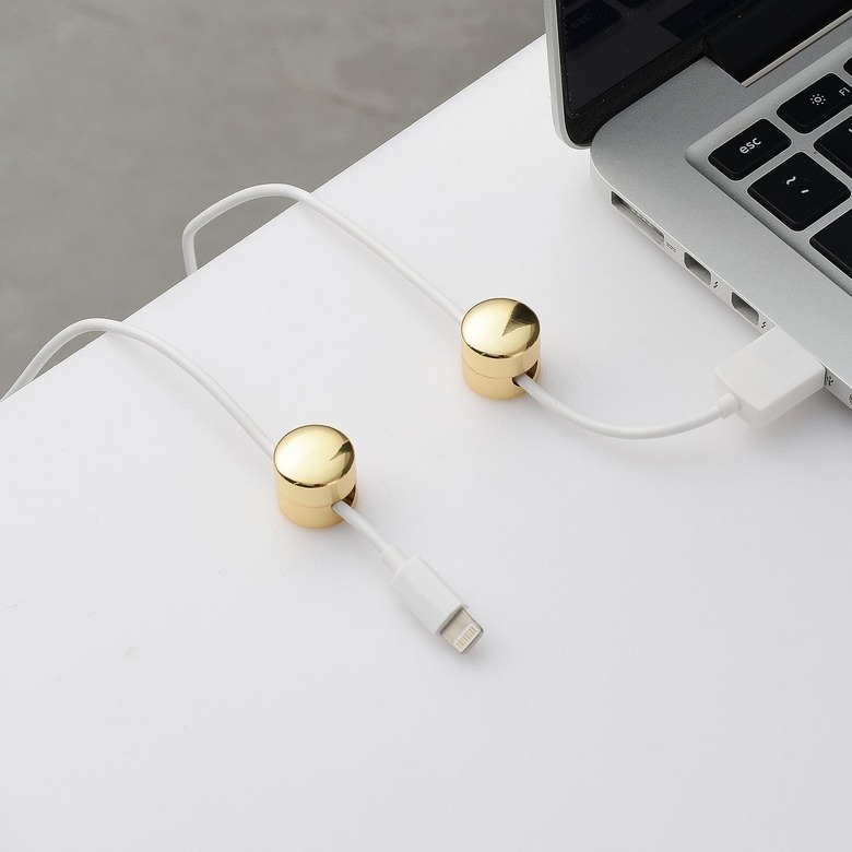 brass button cord keepers on white desk