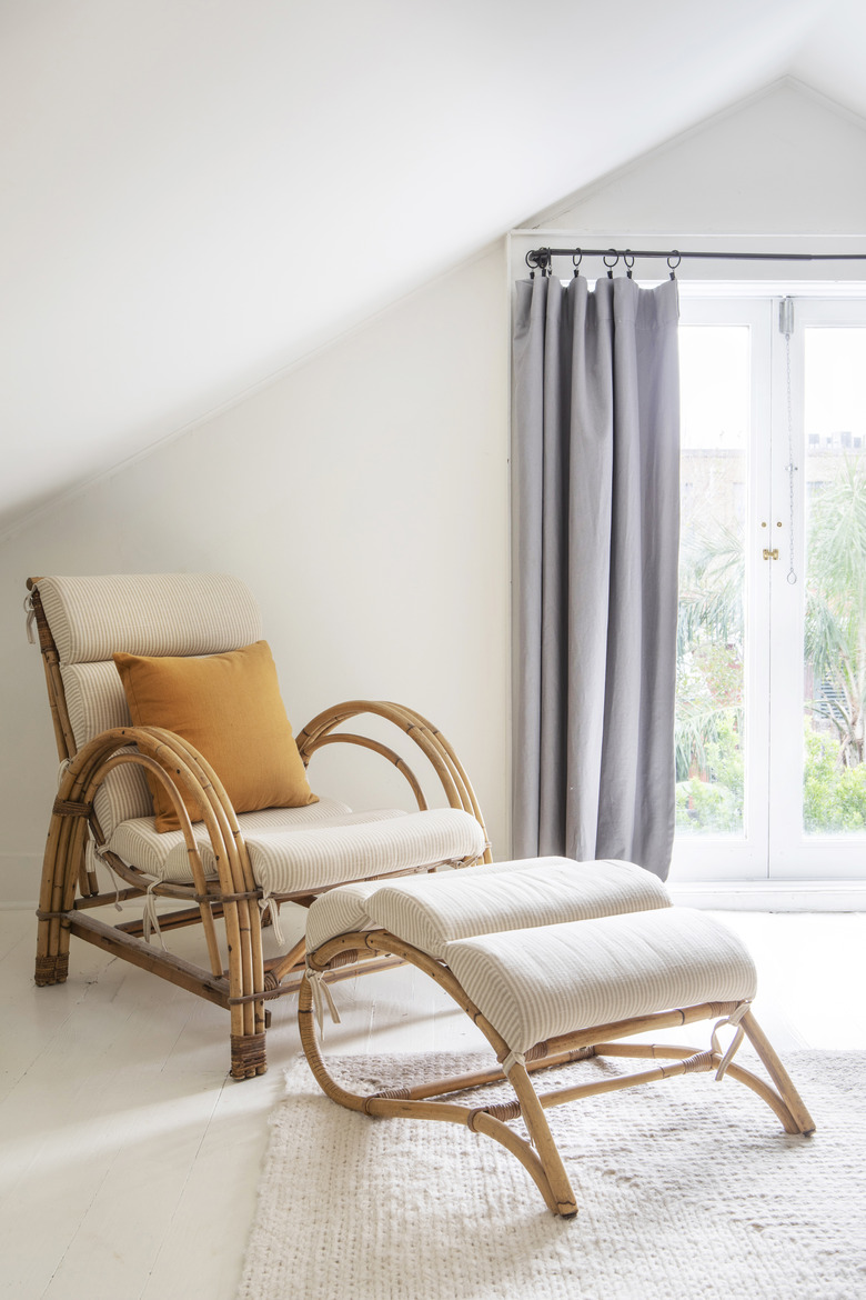 Rattan chair and ottoman with light colored cushion