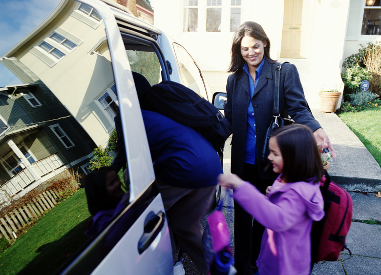 Mother helping son and daughter 6-8 get into mini van