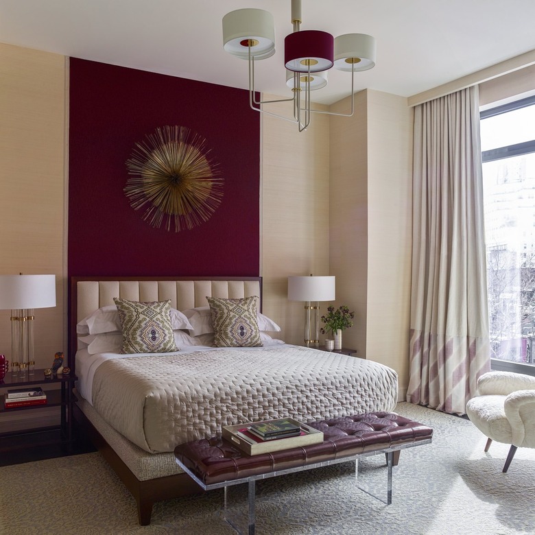 Cream bedroom with maroon accent wall