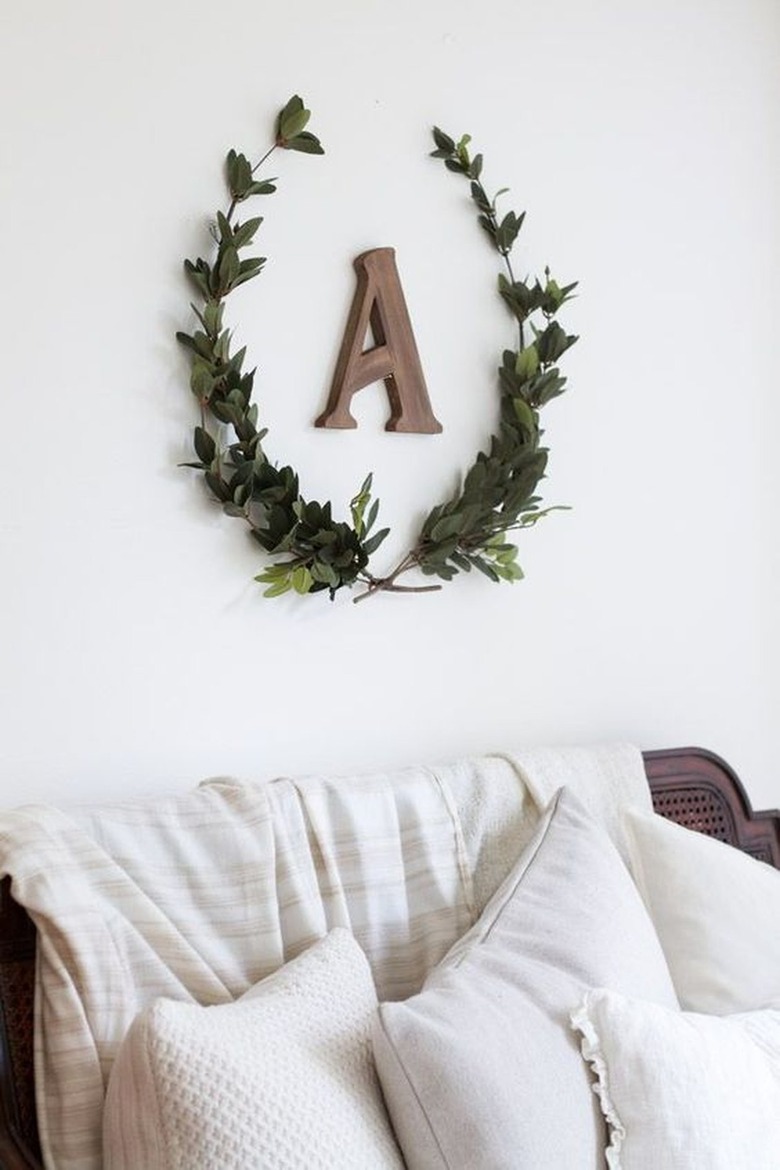 Wreath with an A in the middle above a bed.
