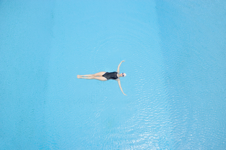 Woman floating in swimming pool