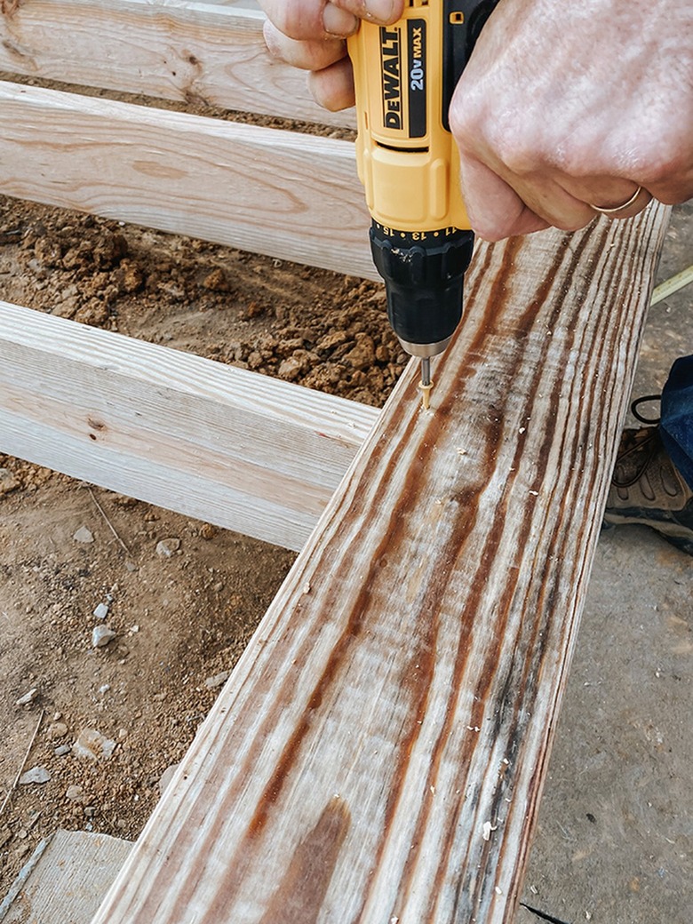 Screw the first deck board down.