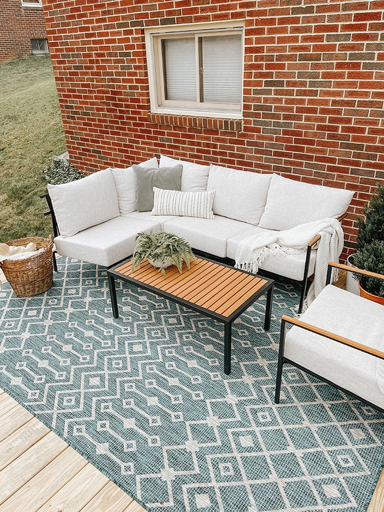 Finish your new DIY deck off with outdoor furniture and a rug.