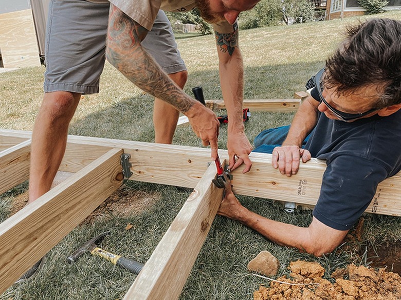 Use joist hangers to attach joists to the deck frame.