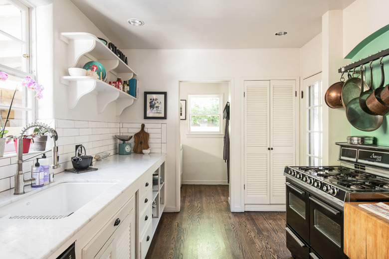 galley kitchen leading into laundry room with double stove