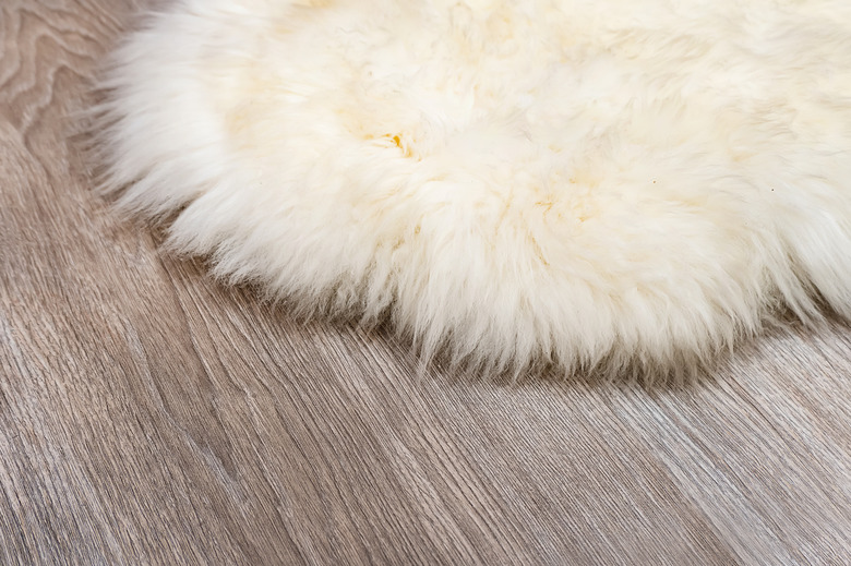 Decorative fur carpet on wood floor background