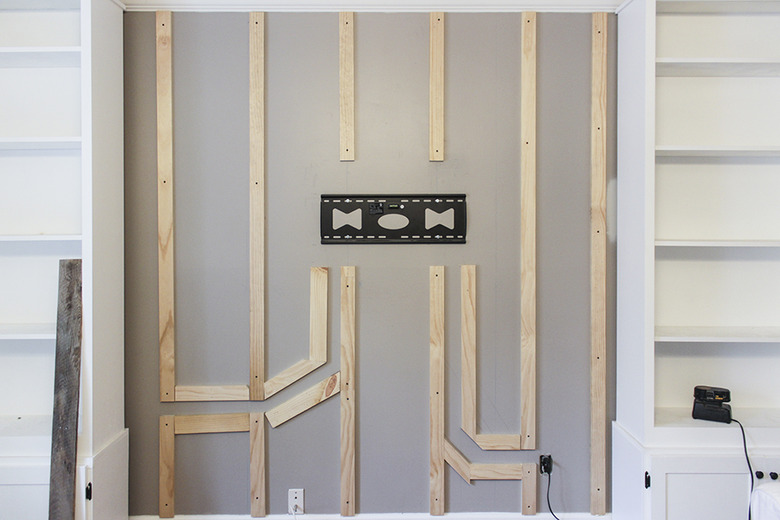 Boards attached to wall with wood paths for wires