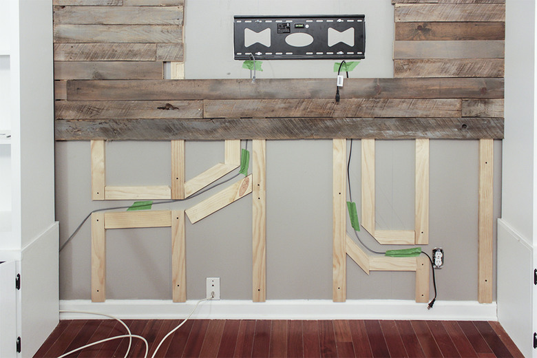Wires running through pathways below TV mount
