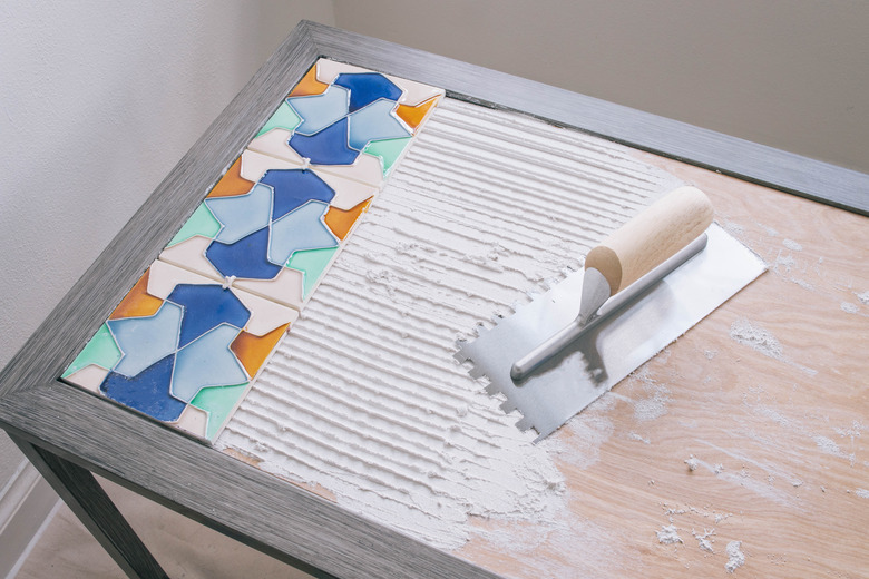 Adhering ceramic tile to table with adhesive