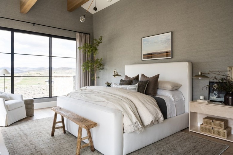 Taupe bedroom with a white bed and large window