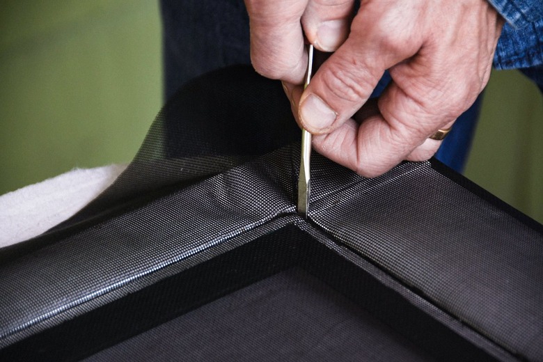 pressing screen spline into groove corners with a screwdriver