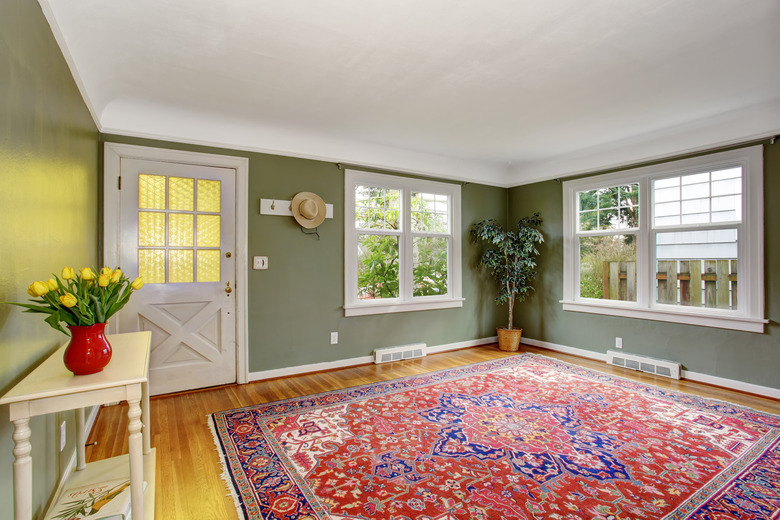 Large front room with chic decor and green walls.