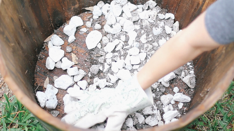 Filling the bottom of a barrel container with rocks