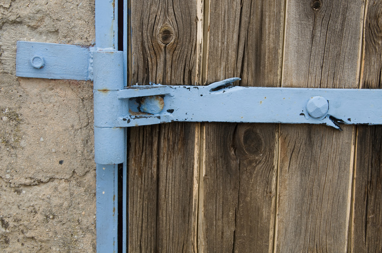 Detail of metal hinge on wooden door