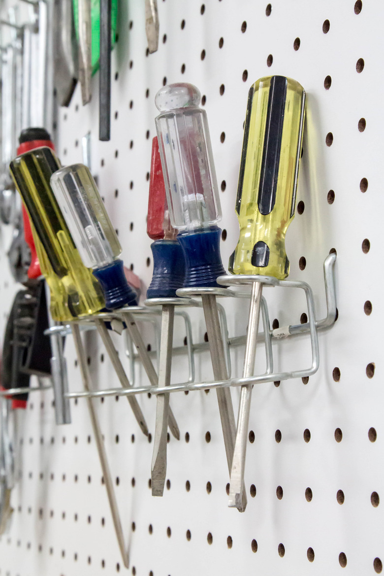 Screwdrivers hanging on a white pegboard