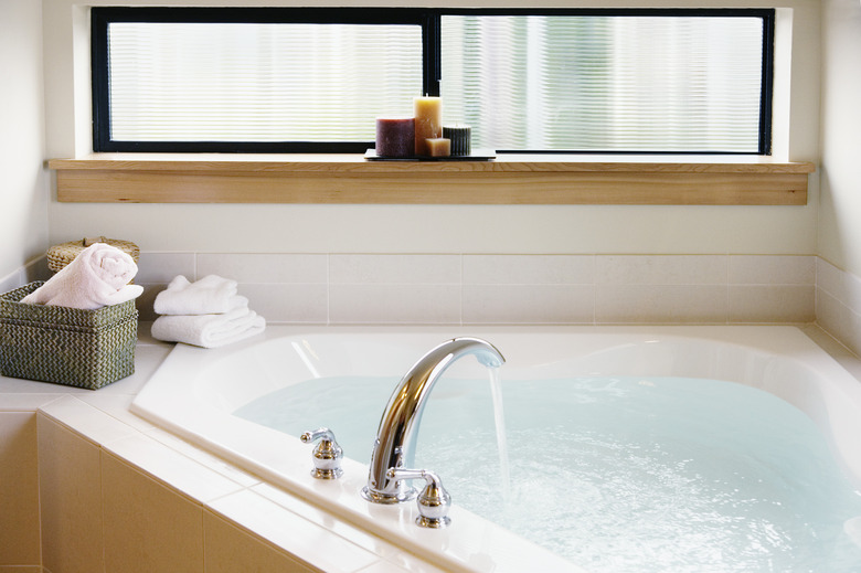 Running water flowing from faucet into bathtub