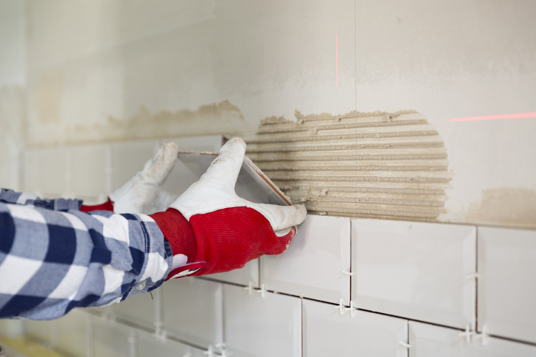 Process of tiling the tiles in the kitchen with necessary tiling tools. Home improvement