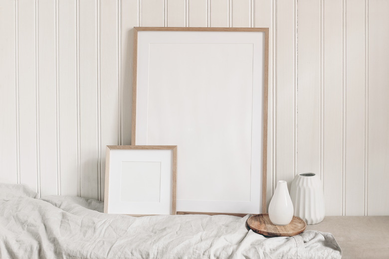 Portrait and square empty wooden frame mockups with linen cloth and modern ceramic vases. White beadboard wainscot wall paneling background. Scandinavian interior