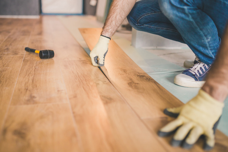 Closeup of master laying laminate flooring