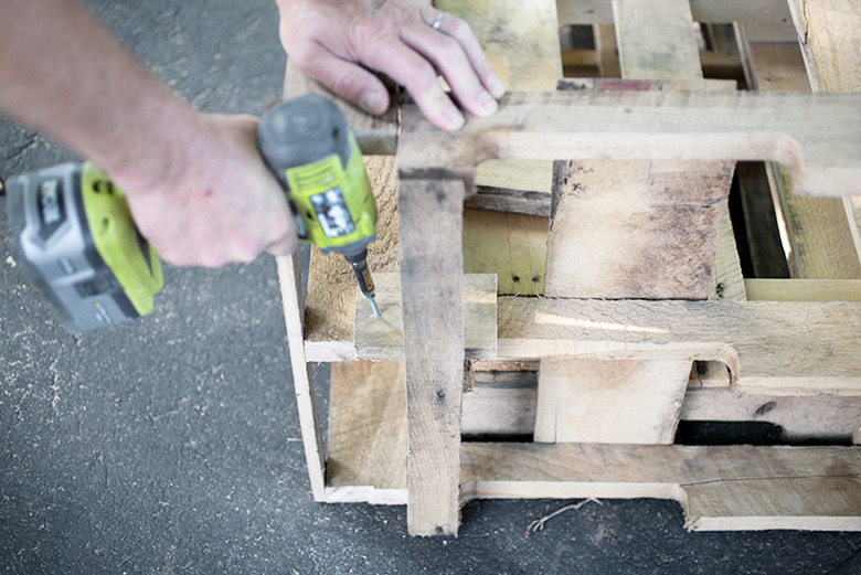 Screw driver screwing pieces of wood together.