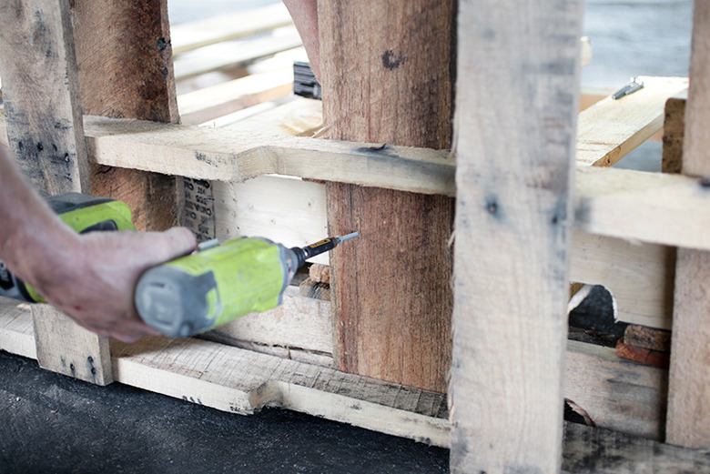 Screw driver screwing pieces of wood together.