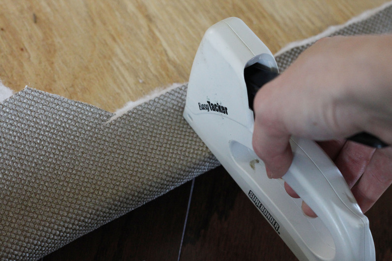 Stapling fabric and batting to the plywood.