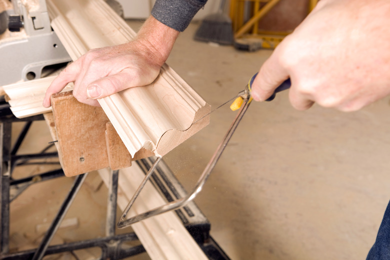 Carpenter Using a Coping Saw to Cut Trim End