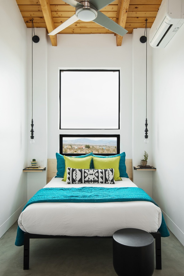 Minimalist bedroom with a wood beam ceiling and a bed with green bedding