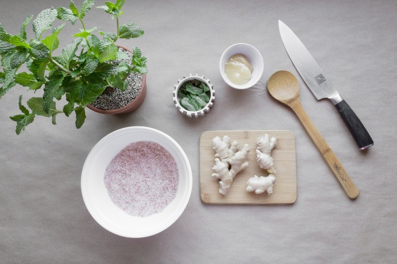 ginger root on a cutting board surrounded by bowls of mint