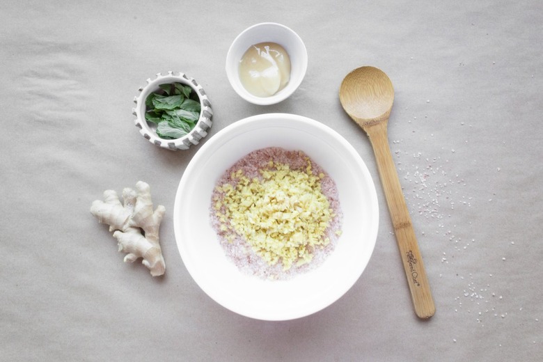 coarse salt and ginger in a bowl surrounded by ginger root