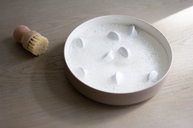 White cabinet hardware soaking in soapy water