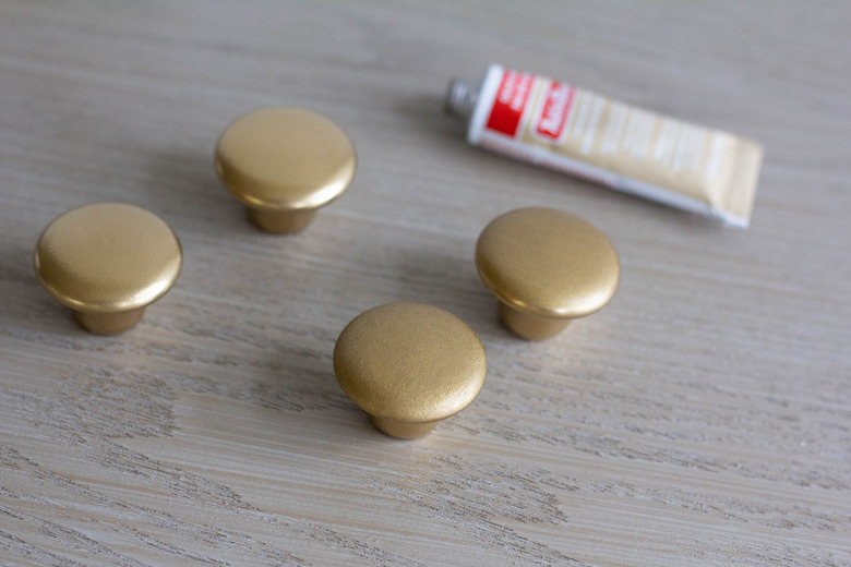 Two gold knots with Rub 'n Buff applied and two gold knobs without it