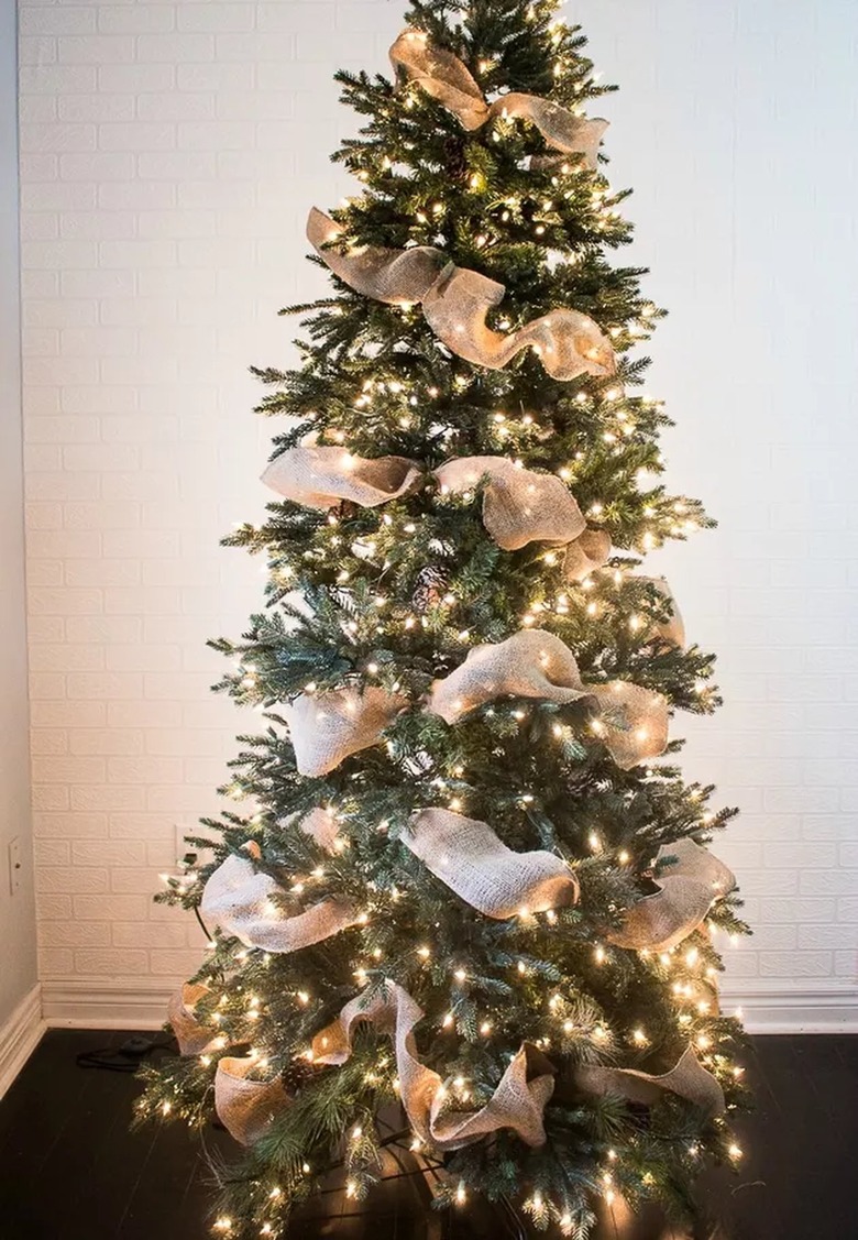A Christmas tree with burlap ribbon from top to bottom
