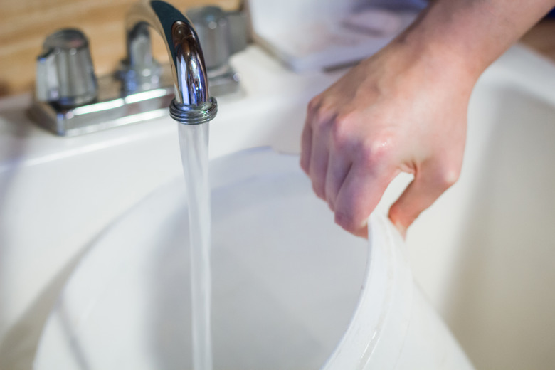 Powder is mixed with water in a bucket.