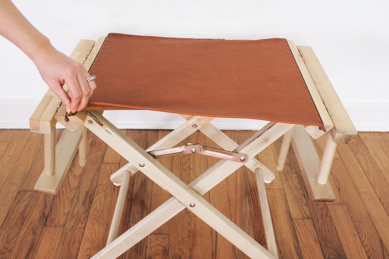 Sliding dowels of new chair seat cover into chair