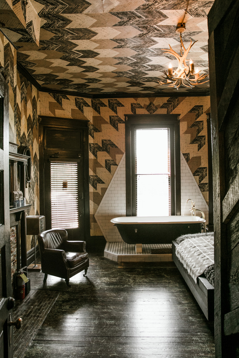 black clawfoot tub on a platform in a bedroom