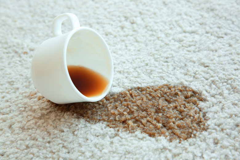 Cup of coffee spilled on white carpet