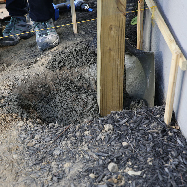 Backfilling a fence post.